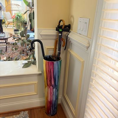 Sale Photo Thumbnail #114: A colorful, rainbow dripped-paint effect umbrella stand holding an assortment of walking canes and umbrellas.