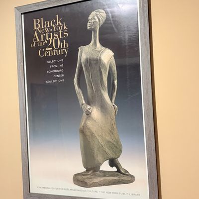 Sale Photo Thumbnail #214: Framed exhibition poster for 'Black New York Artists of the 20th Century' from the Schomburg Center for Research in Black Culture, featuring a sculpted figure on a dark background.