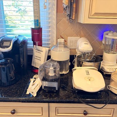 Sale Photo Thumbnail #92: Collection of small kitchen appliances on a countertop, including a Keurig coffee maker, SodaStream, Cuisinart food processor, stand mixer, and George Foreman grill.