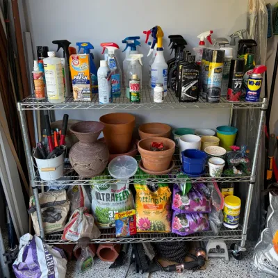 Sale Photo Thumbnail #87: Four-tier wire shelving unit filled with household cleaning supplies, automotive sprays, terracotta planters, ceramic pots, and lawn care products.