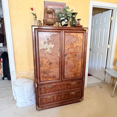 Sale Photo Thumbnail #285: Vintage Asian-style wooden armoire featuring carved landscape door panels, brass hardware, and two bottom drawers.
