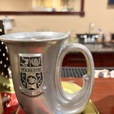 Sale Photo Thumbnail #165: Vintage Michelob pewter-style horn stein featuring an embossed coat of arms crest.