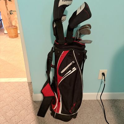 Sale Photo Thumbnail #262: Pinemeadow Golf Pre set of golf clubs housed in a black, red, and white stand bag with headcovers.