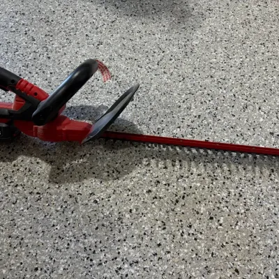 Sale Photo Thumbnail #57: Bauer 20V lithium-ion cordless hedge trimmer with red casing and attached battery pack.
