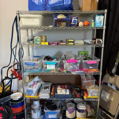Sale Photo Thumbnail #75: Five-tier metal wire baker's rack loaded with various household, hardware, paint, and storage items.