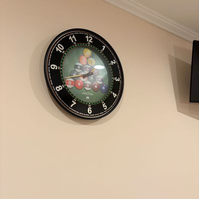 Sale Photo Thumbnail #240: Sterling & Noble novelty billiards-themed wall clock featuring a racked pool ball graphic face and black rim.
