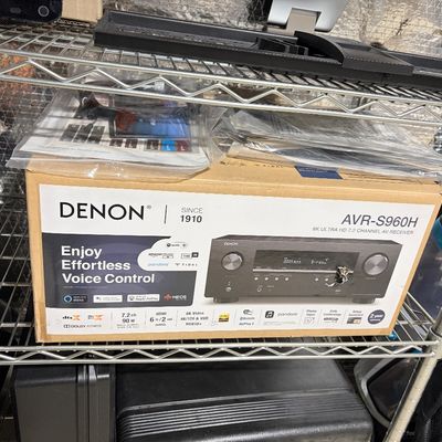 Sale Photo Thumbnail #208: Denon AVR-S960H 8K Ultra HD 7.2 Channel AV Receiver, boxed with manuals, sitting on a wire storage rack.