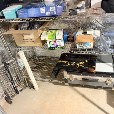 Sale Photo Thumbnail #201: Wire storage shelving rack holding various computer parts, boxed electronics, an ASUS laptop, and a hard road case.