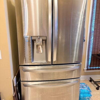 Sale Photo Thumbnail #156: Modern LG stainless steel French door refrigerator featuring an in-door water and ice dispenser, middle drawer, and bottom freezer.