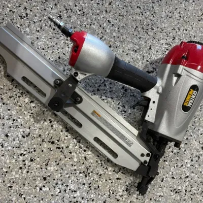 Sale Photo Thumbnail #58: Central Pneumatic air-powered framing nailer with red and silver housing, appearing in lightly used condition.