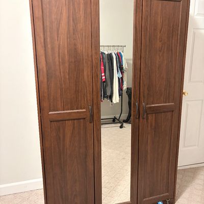 Sale Photo Thumbnail #225: Modern dark wood three-door wardrobe armoire featuring a full-length mirrored center door and metal pull handles.
