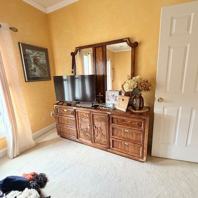 Sale Photo Thumbnail #282: Vintage Asian-style wooden dresser with carved door panels and matching attached split mirror, paired with a flat-screen television.