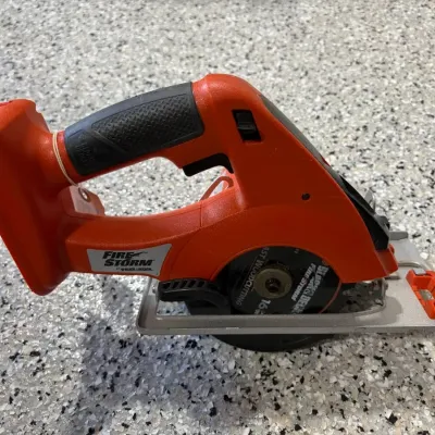 Sale Photo Thumbnail #67: Black & Decker FireStorm cordless circular saw in orange casing, showing light cosmetic wear.
