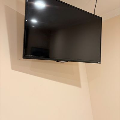 Sale Photo Thumbnail #239: Wall-mounted Vizio flat screen television with thin black bezel.