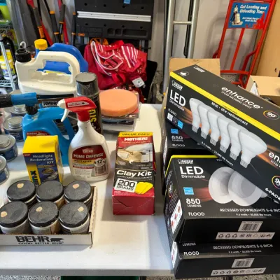 Sale Photo Thumbnail #84: Collection of home maintenance, automotive care, and lighting products, including Feit Electric LED bulb multipacks, Sterno cans, Behr sample jars, and Mothers clay kit.