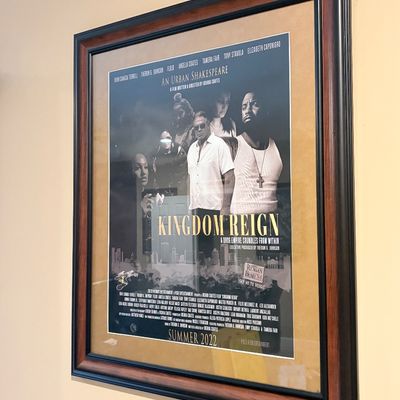 Sale Photo Thumbnail #217: Framed promotional movie poster for the 2022 film 'Kingdom Reign: An Urban Shakespeare', mounted with a beige mat inside a dark wood-finish frame.