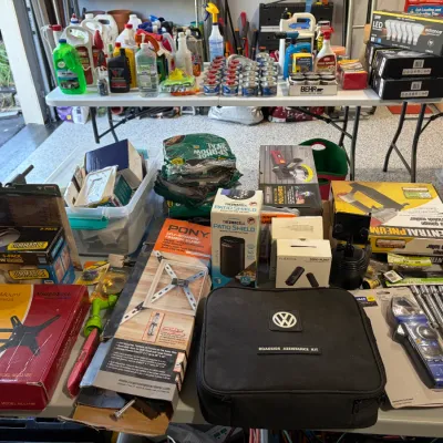 Sale Photo Thumbnail #79: Assortment of household goods, tools, and automotive supplies, including a Volkswagen roadside assistance kit, pneumatic nailer, and cleaning chemicals.