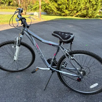 Sale Photo Thumbnail #53: Huffy Scout silver mountain bike featuring a front suspension fork, gel seat cover, and kickstand.