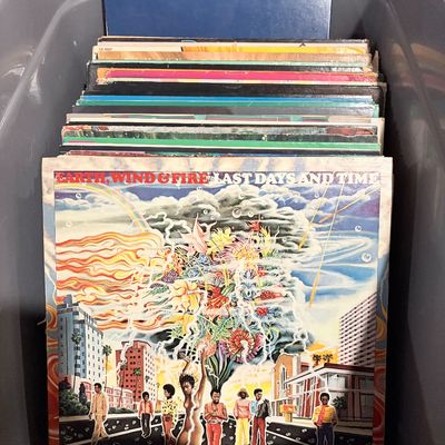 Sale Photo Thumbnail #175: Plastic storage container filled with vintage vinyl records, featuring Earth, Wind & Fire's 1972 album 'Last Days and Time' displayed at the front.