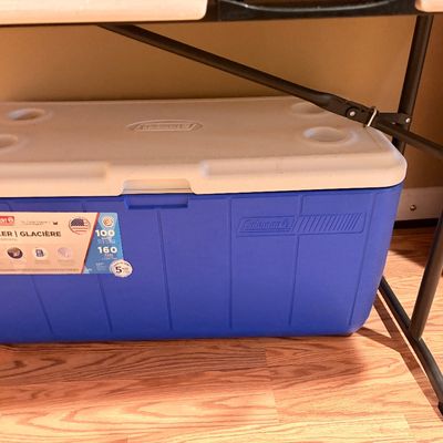 Sale Photo Thumbnail #235: Large blue and white Coleman 100-quart plastic ice chest cooler with built-in lid cup holders.
