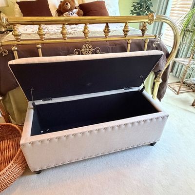 Sale Photo Thumbnail #289: Contemporary beige fabric storage ottoman with nailhead trim detail and hinged open lid.
