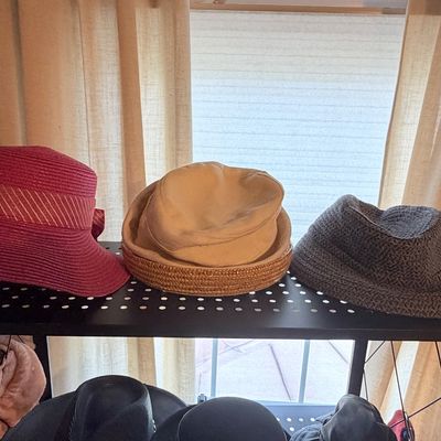 Sale Photo Thumbnail #269: Collection of women's vintage sun hats and bucket hats displayed on a metal shelf.