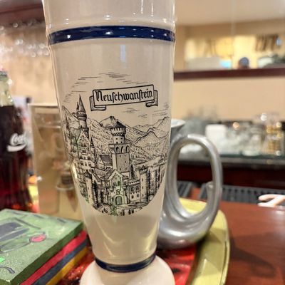 Sale Photo Thumbnail #166: Vintage ceramic Neuschwanstein beer glass featuring a black and white illustration of the German castle and blue trim accents.