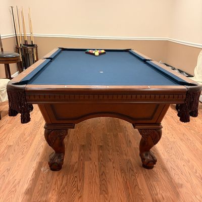 Sale Photo Thumbnail #244: Traditional wood pool table with blue felt, carved ball-and-claw feet, fringe leather pockets, and set of billiard balls.