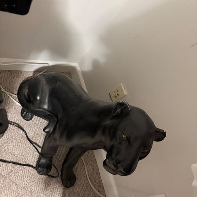 Sale Photo Thumbnail #230: Vintage mid-century modern style black panther floor statue, featuring a crouching pose with detailed amber eyes and a glossy finish.