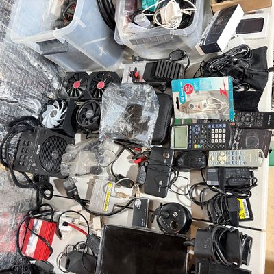 Sale Photo Thumbnail #198: Assortment of computer electronics and accessories including an EVGA power supply, cooling fans, power adapters, graphing calculator, remotes, and cables.