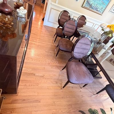 Sale Photo Thumbnail #111: Modern dining room set featuring a glass-top table, dark wood frame, and oval upholstered chairs with plush fabric backs.