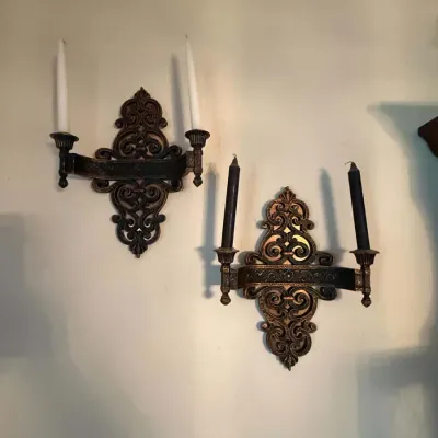 Sale Photo Thumbnail #42: Pair of ornate vintage wrought iron wall sconces with two candle holders each, featuring intricate scrollwork backplates.