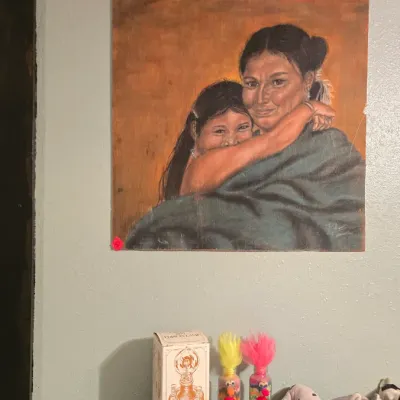 Sale Photo Thumbnail #10: Original portrait painting of a mother and child hanging on a wall above a wooden headboard, accompanied by decorative sand bottles and plush toys.