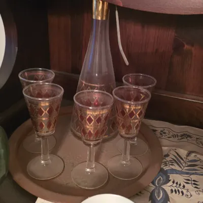 Sale Photo Thumbnail #63: Vintage glass liquor set featuring a decanter and matching cordial glasses with red and gold diamond patterns, arranged on a tray.