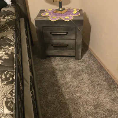 Sale Photo Thumbnail #27: Modern rustic two-drawer nightstand in a weathered grey finish, topped with a brass adjustable desk lamp and a purple and yellow crocheted doily.