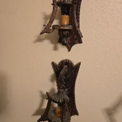 Sale Photo Thumbnail #6: Pair of carved dark wood wall sconces featuring intricate detailing and suspended lantern-style candle holders.