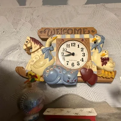 Sale Photo Thumbnail #29: Vintage New Haven country-style wall clock featuring resin figures of geese, a sleeping cat, a rocking horse, and a "Welcome" sign.