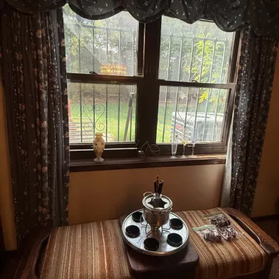 Sale Photo Thumbnail #40: Vintage fondue set with pot, forks, and sauce inserts displayed on a striped fabric bench in front of a window.