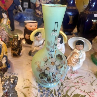 Sale Photo Thumbnail #96: Hand-painted pale green satin art glass vase featuring floral designs with gilt accents, displayed alongside Asian figurines and cobalt ceramics.