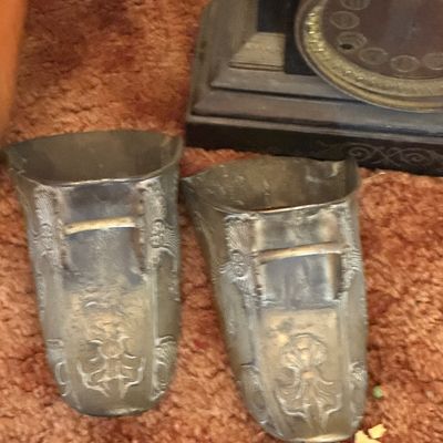 Sale Photo Thumbnail #56: Pair of antique embossed metal boot stirrups or vases shown alongside an antique shelf clock.