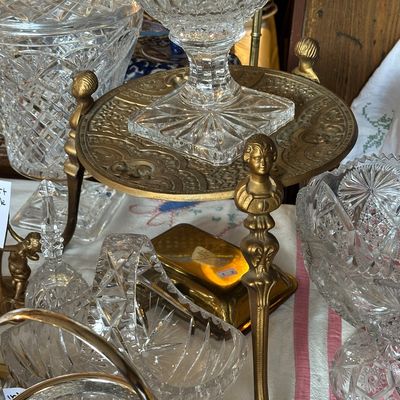 Sale Photo Thumbnail #27: Collection of vintage cut glass tableware and a brass stand featuring figural bust legs and a claw foot base.