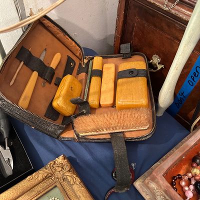 Sale Photo Thumbnail #8: Vintage zippered travel grooming and shoe shine kit with yellowed celluloid or bakelite handles and tools, housed in a worn leather case.