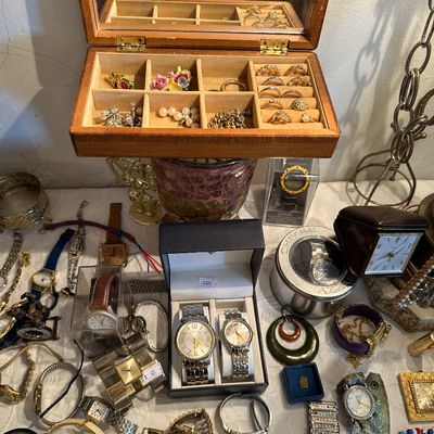 Sale Photo Thumbnail #22: Collection of assorted vintage and contemporary jewelry and wristwatches, including a wooden jewelry box filled with rings and small trinkets, surrounded by various men's and women's watches.