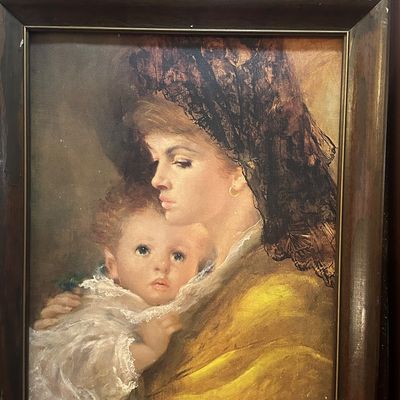 Sale Photo Thumbnail #110: Framed vintage art print of a mother and child by A. Gentilini, housed in a dark wooden frame with brass inner trim.
