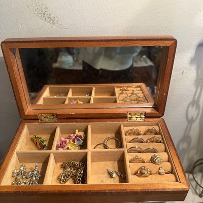 Sale Photo Thumbnail #71: Open wooden jewelry box featuring an interior mirror, velvet-lined compartments, ring slots, and assorted costume jewelry.