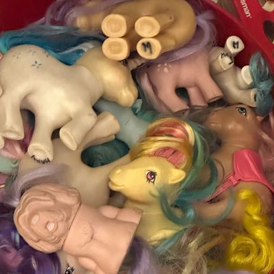 Sale Photo Thumbnail #46: Collection of vintage My Little Pony and similar toy figures inside a round container, showing play wear and some handwritten markings.