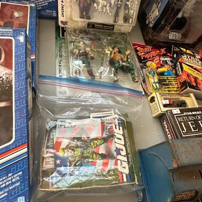 Sale Photo Thumbnail #52: Collection of vintage pop culture toys and collectibles, including G.I. Joe boxed figures, KISS action figures in blister packaging, and Star Wars merchandise.