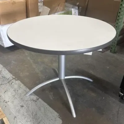 Sale Photo Thumbnail #5: Modern round bistro table featuring an off-white laminate top with gray trim and a silver-toned metallic pedestal base.