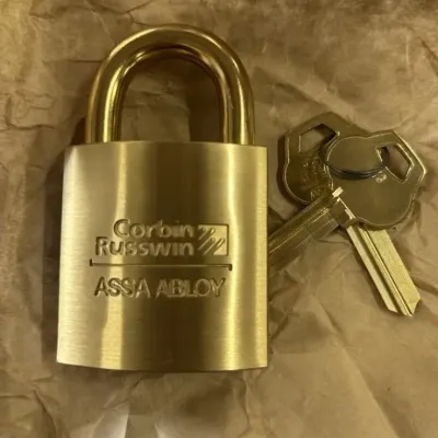 Sale Photo Thumbnail #10: Solid brass Corbin Russwin ASSA ABLOY heavy-duty padlock accompanied by a pair of original keys.