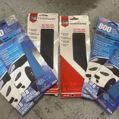 Sale Photo Thumbnail #148: Assortment of automotive sandpaper packs, including 3M 400 grit, 3M 800 grit, and Surebilt wet or dry sandpaper.